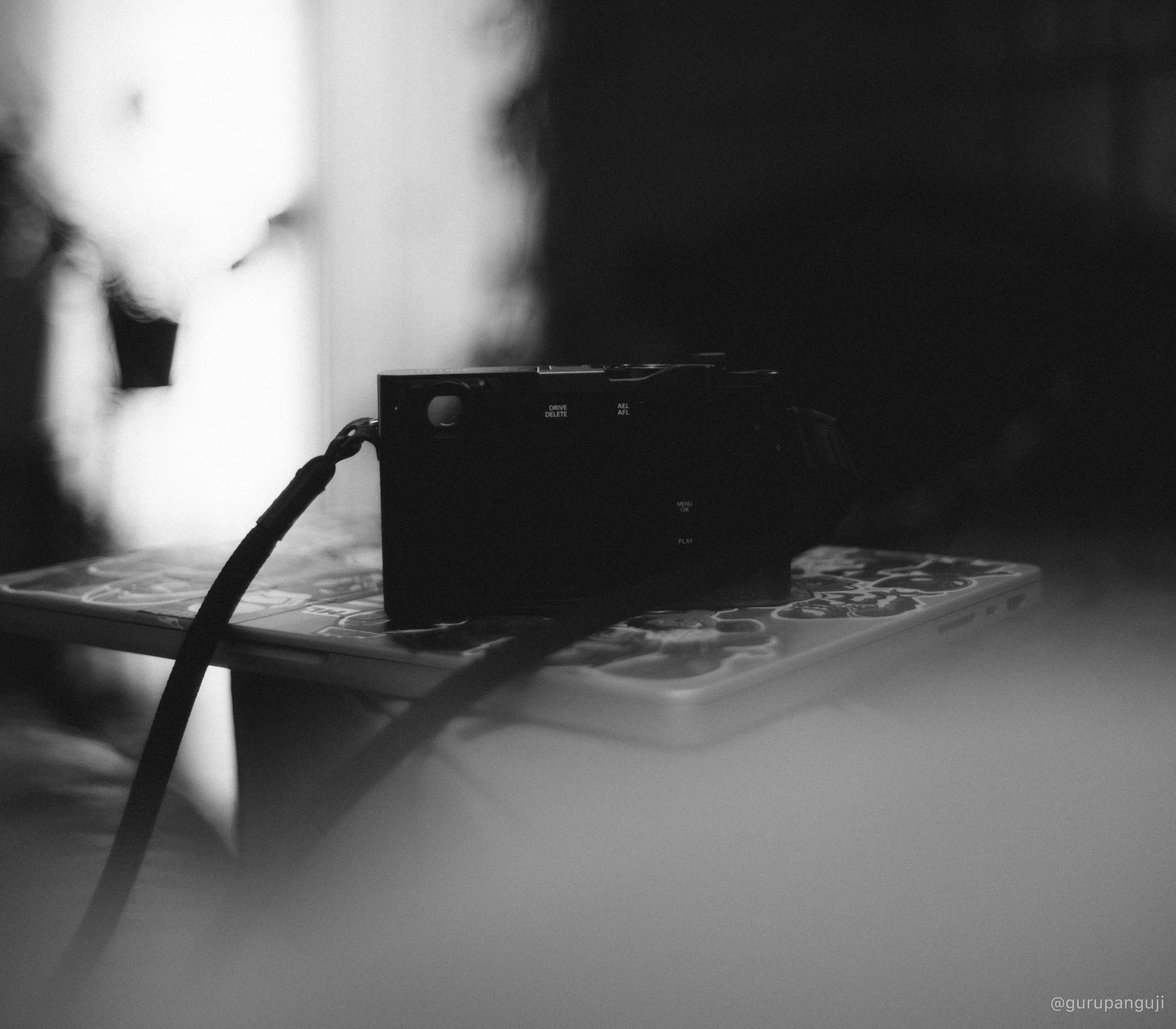 A guitar placed with a Fujifilm X100VI to represent compact creative tooling