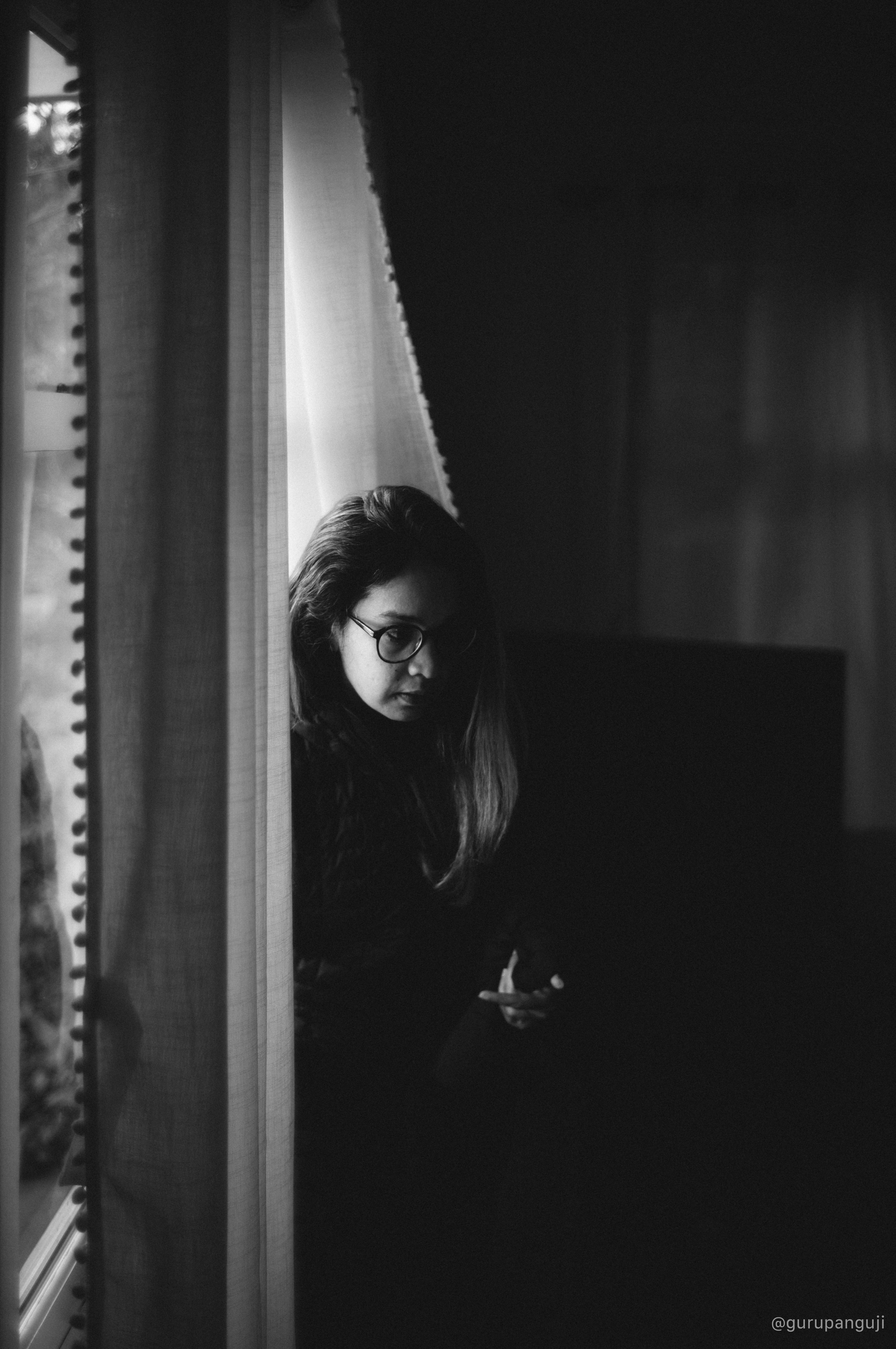 Low-light portrait by a window in monochrome